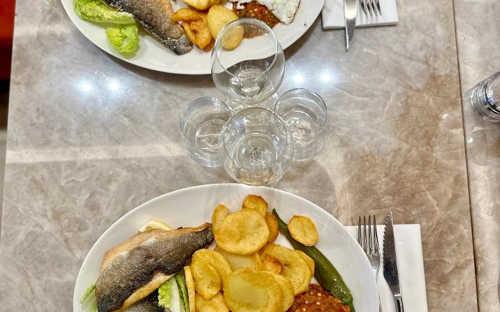 Deux assiettes de poisson grillé accompagnées de pommes de terre et d'un œuf au plat