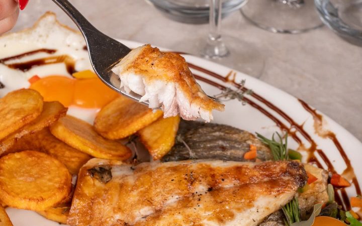 Un filet de poisson grillé servi avec des pommes de terre et une salade