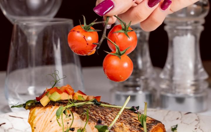 Un filet de saumon grillé servi sur une purée avec des tomates cerises en grappe
