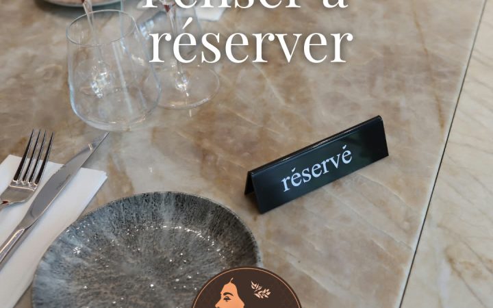 Une table dressée avec des verres, des couverts et un panneau de réservation